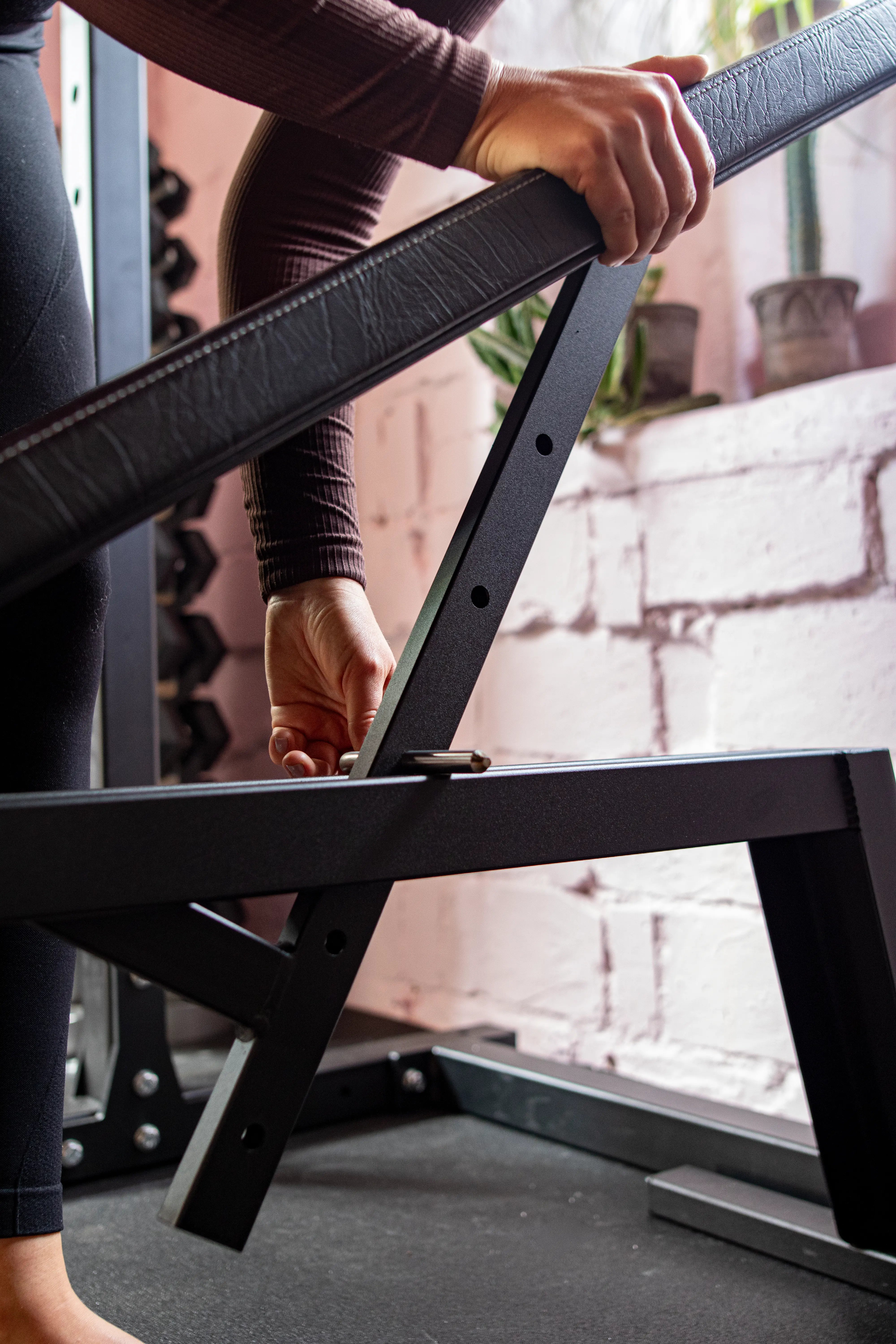 Person assembling a bench with a black metal frame with a blurred background