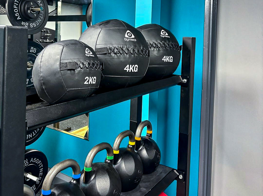 A picture with medicine balls and kettlebells.