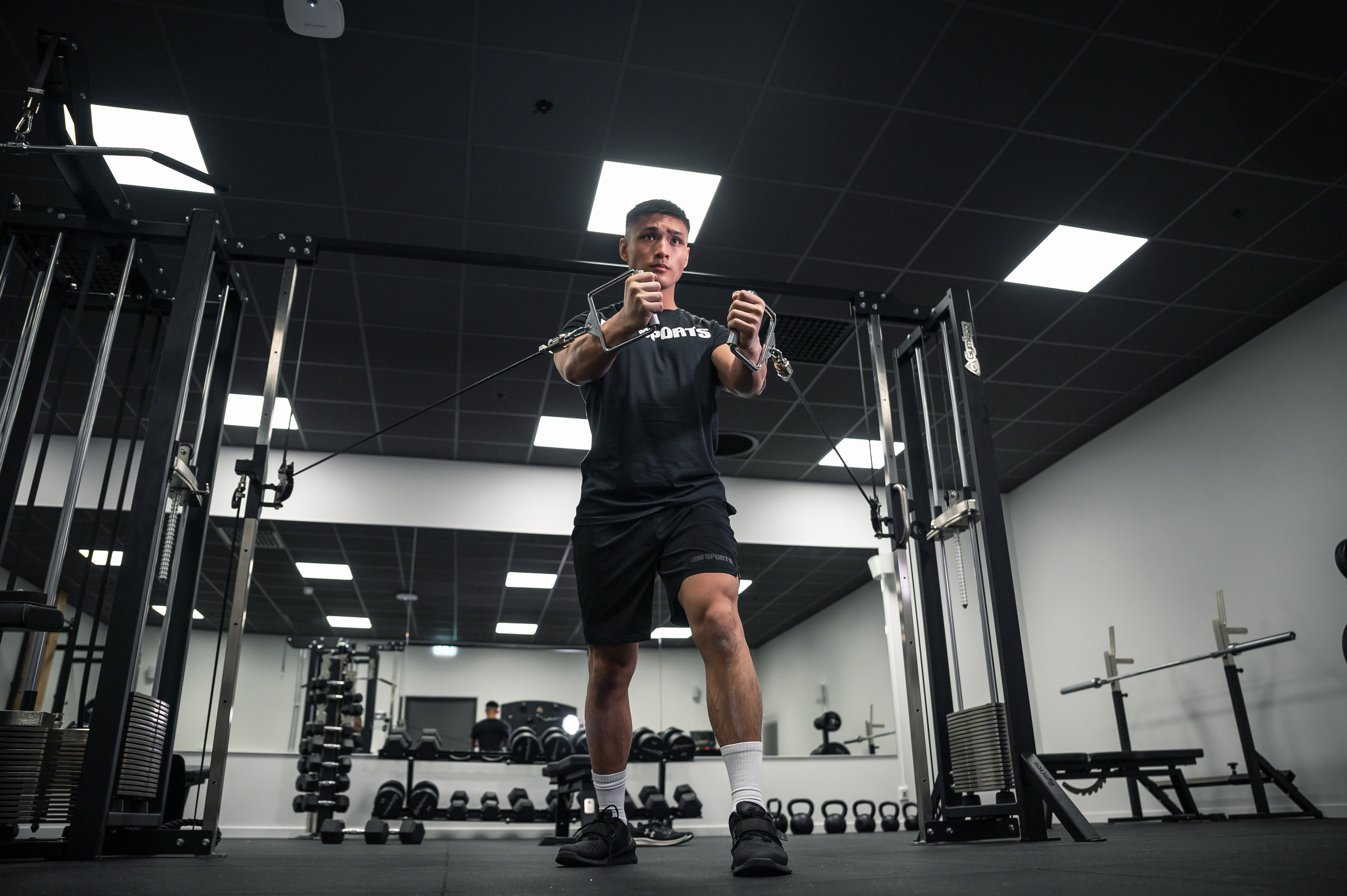Guy working out with Gymleco cable machine.