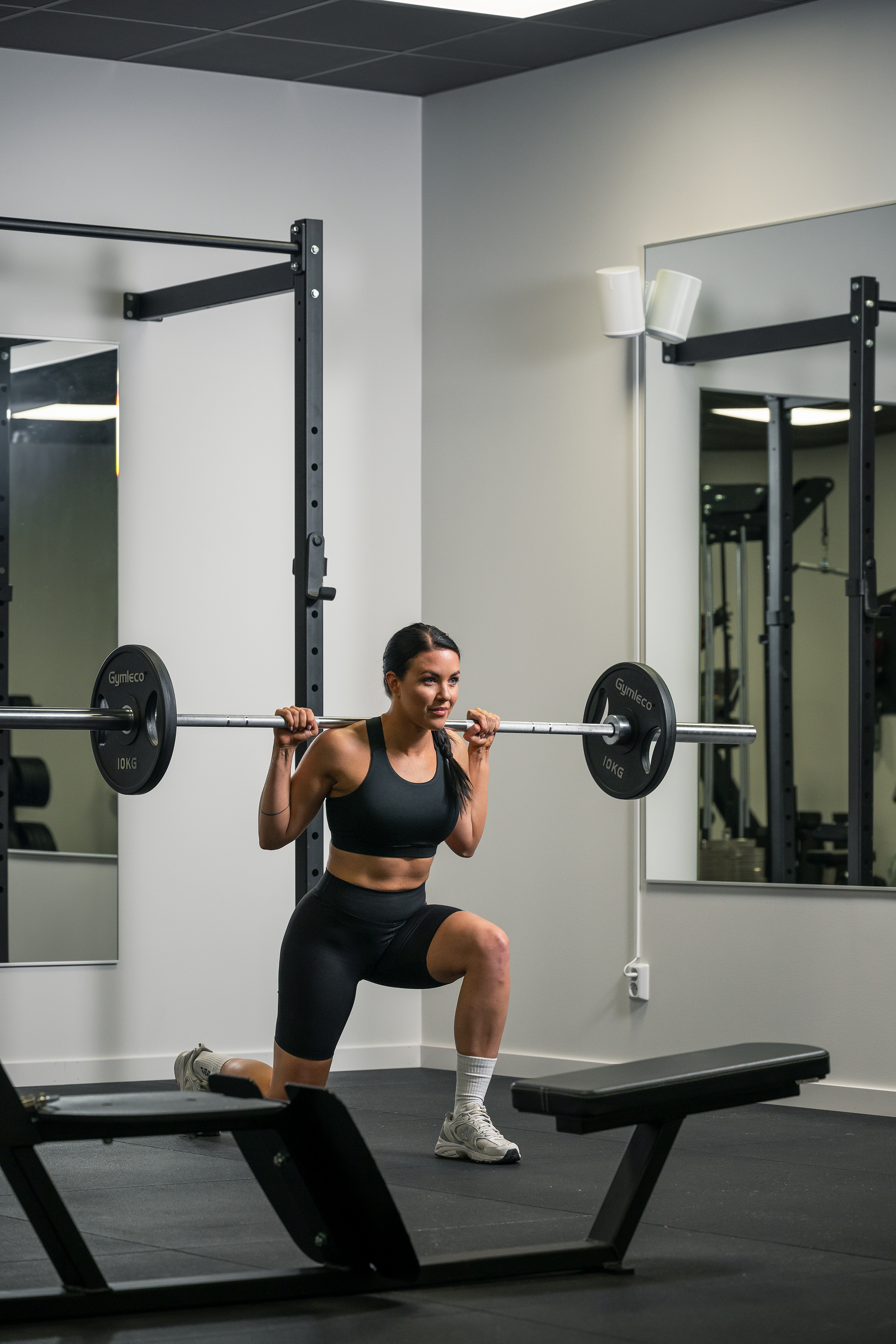 Person working out with Gymleco barbell and weights. Doing lounges.