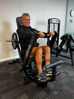 A woman hapilly working out on a Gymleco machine.