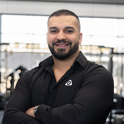 Saad at Gymleco. Man wearing a black shirt with a logo in an indoor setting