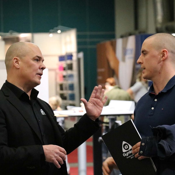 two gymleco employees talking to each other - två gymleco anställda pratar med varandra