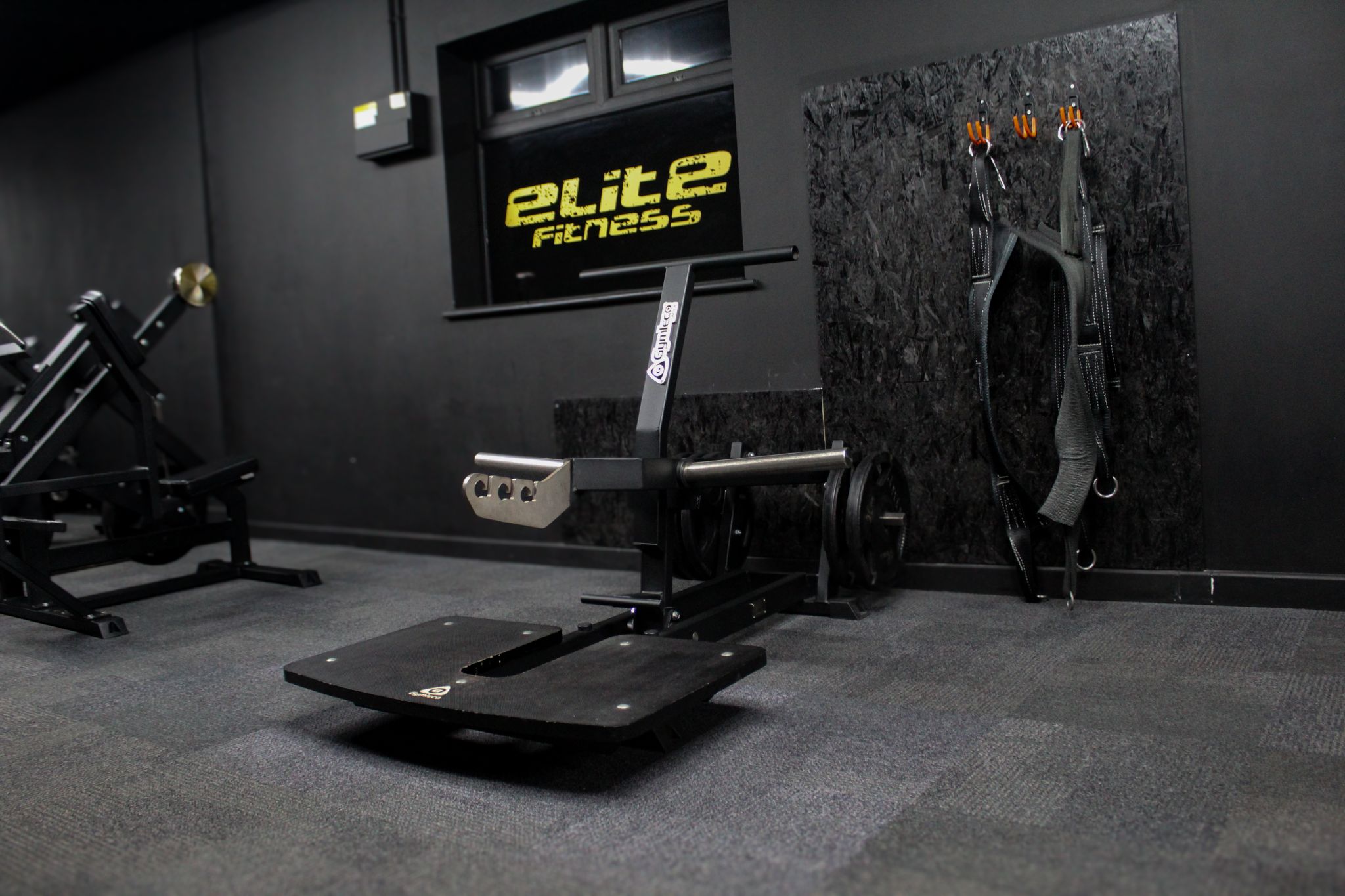 A picture of a 082 belt squat gym machine from Gymleco. Standing in a gym environment.
