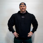 Man wearing a black hoodie with 'Gymleco' logo against a white background