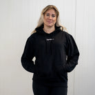 Person wearing a black hoodie with a "Gymleco" logo on a white background