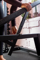 Person assembling a bench with a black metal frame with a blurred background